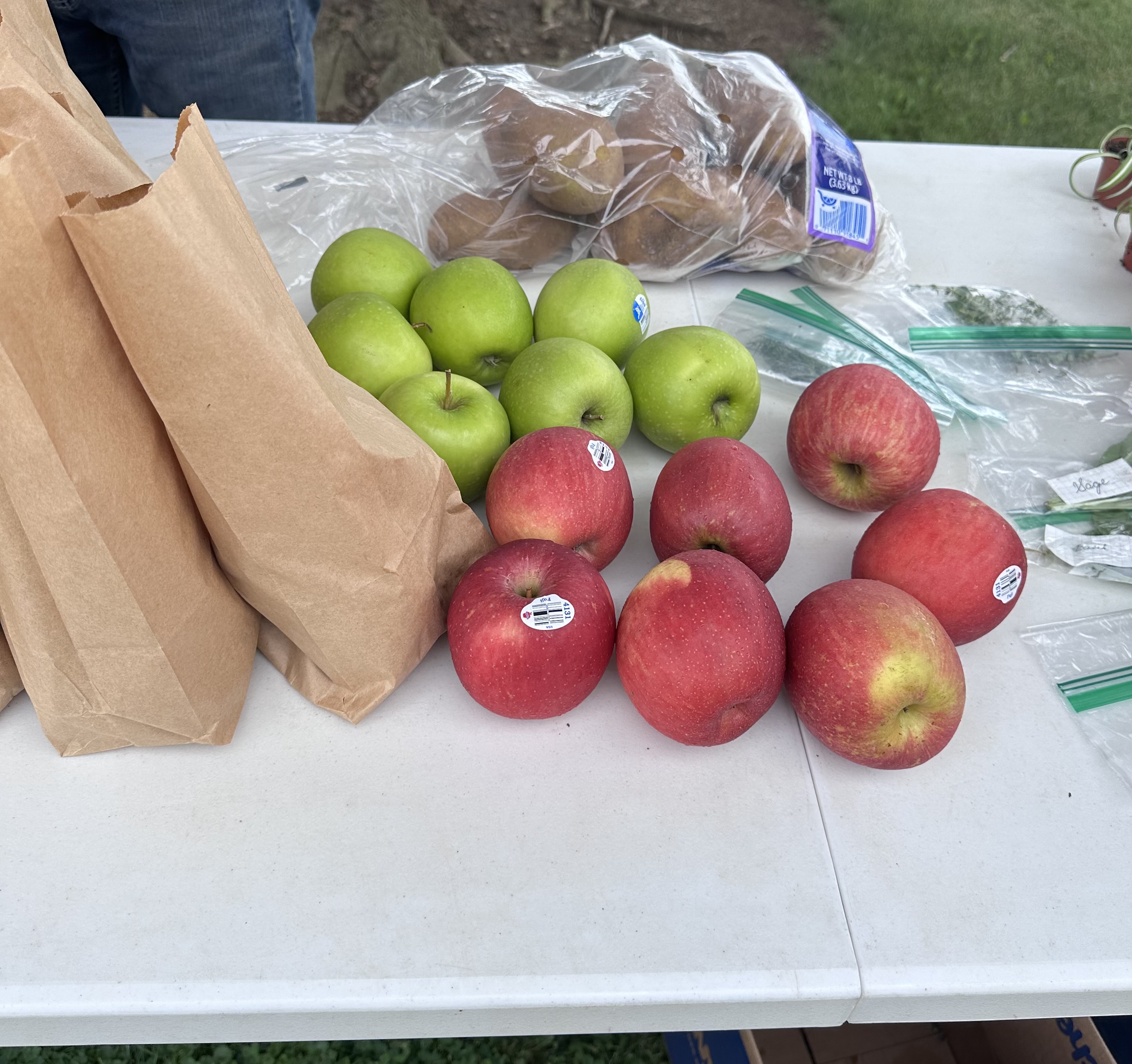 Apples, potatoes, and brown paper bags ready for neighbors